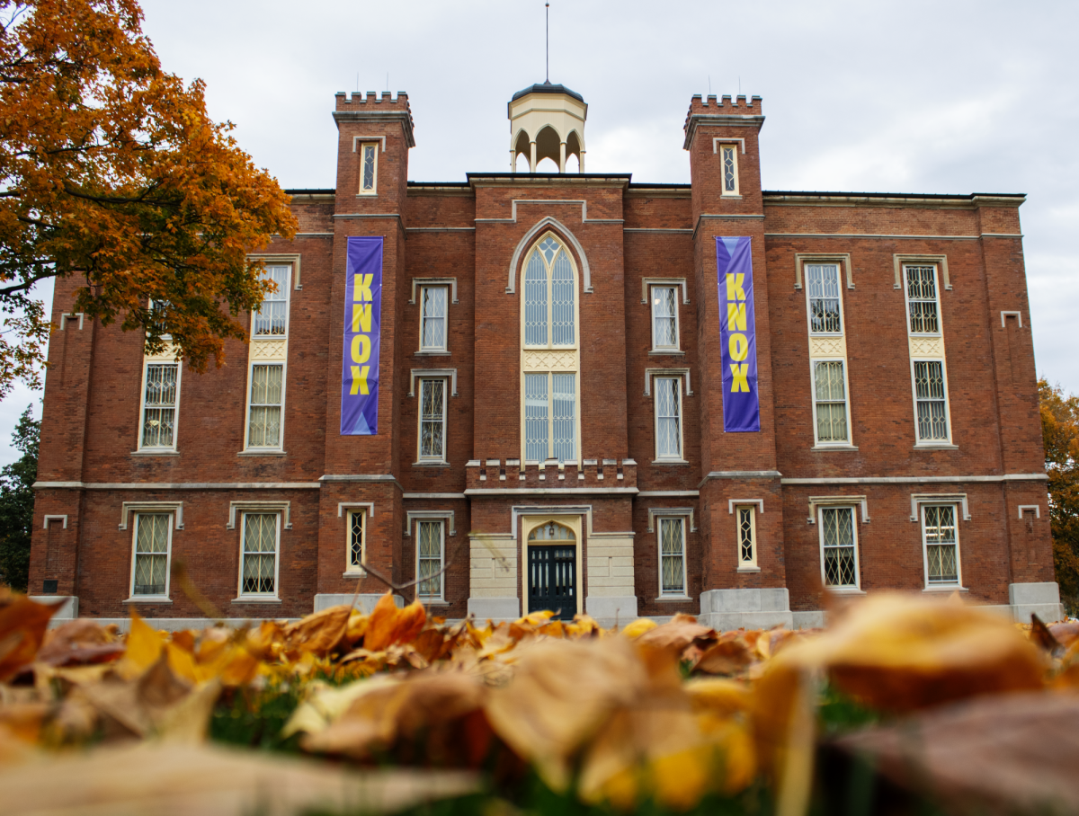 Image of Knox College's Old Main building shot from the ground with fall foliage in the foreground.